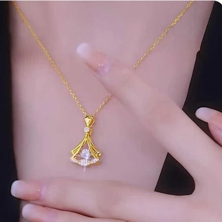 Gold necklace with a pendant on a person's neck