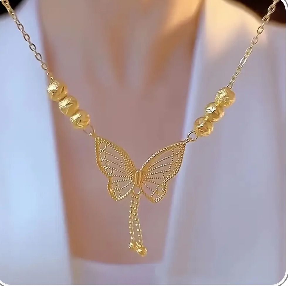 Gold butterfly necklace with beads on a white background