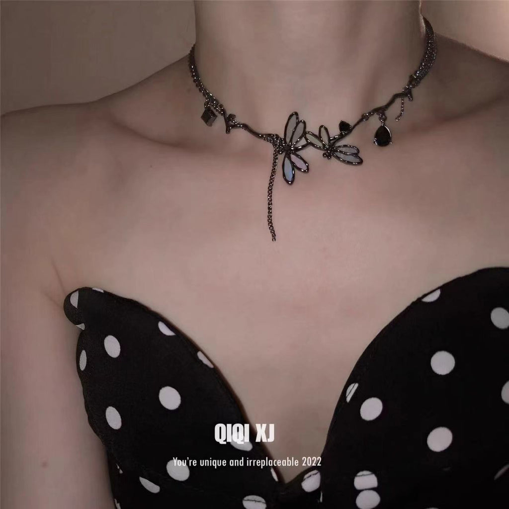 Necklace with floral design worn by a person, with 'QI Qi XJ' branding in the corner.