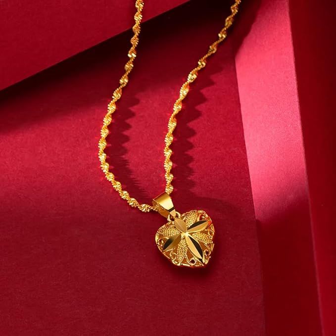 Gold necklace with a heart-shaped pendant on a red background
