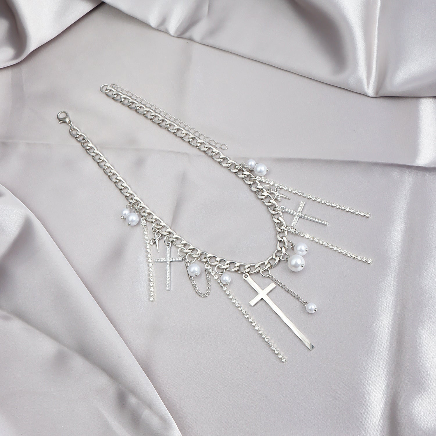 Silver bracelet with charms on a light gray fabric background