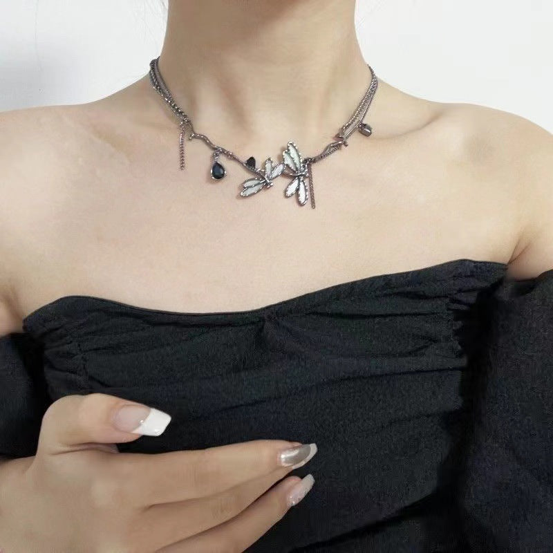 Necklace with leaf and stone design worn by a person in a black top.