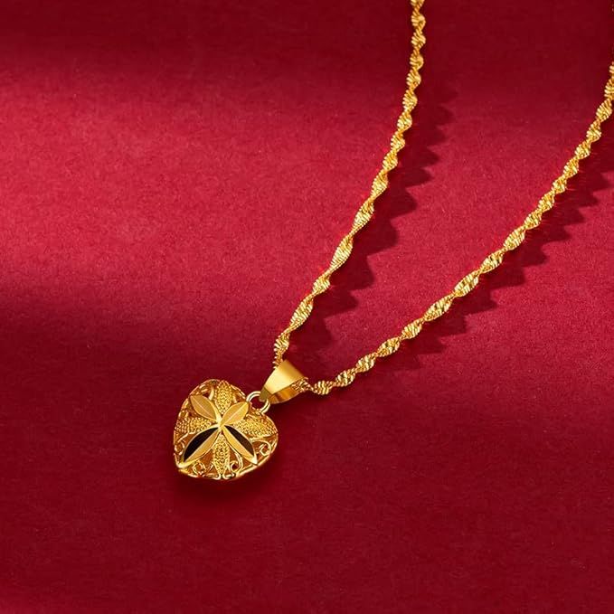 Gold necklace with a heart-shaped pendant on a red background