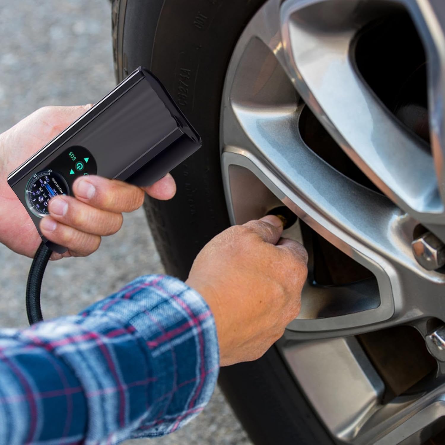 Person using a digital tire pressure gauge on a car tire high-pressure air pump