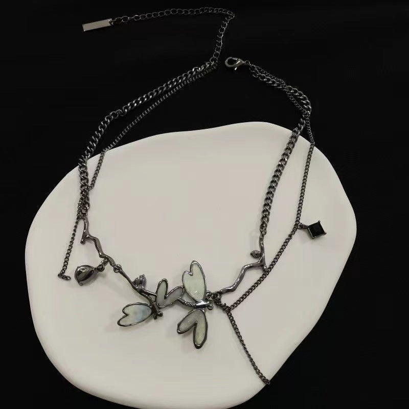 Necklace with butterfly pendants on a white stone surface